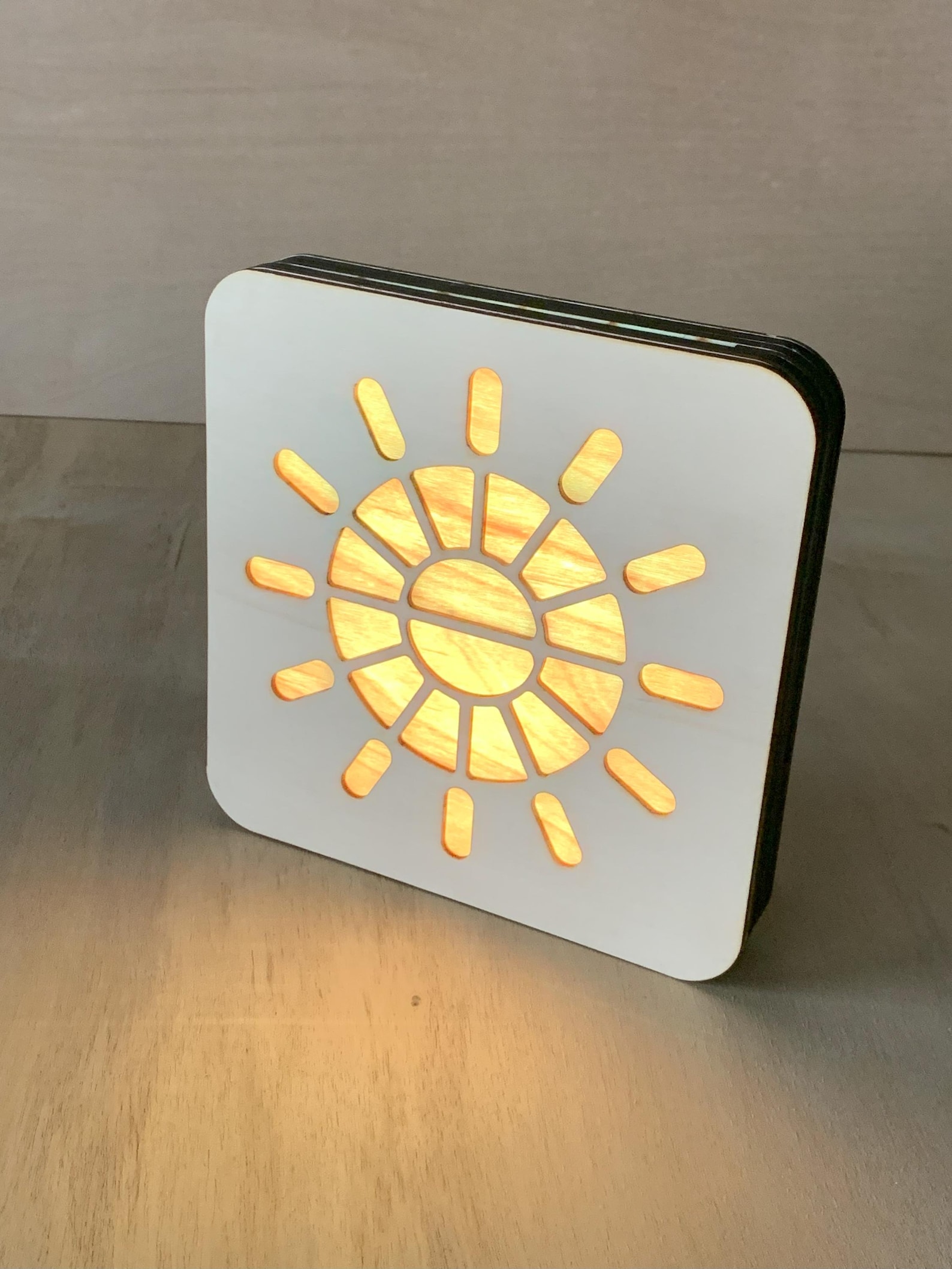 HelioKron sunrise and sunset clock glowing on a shelf