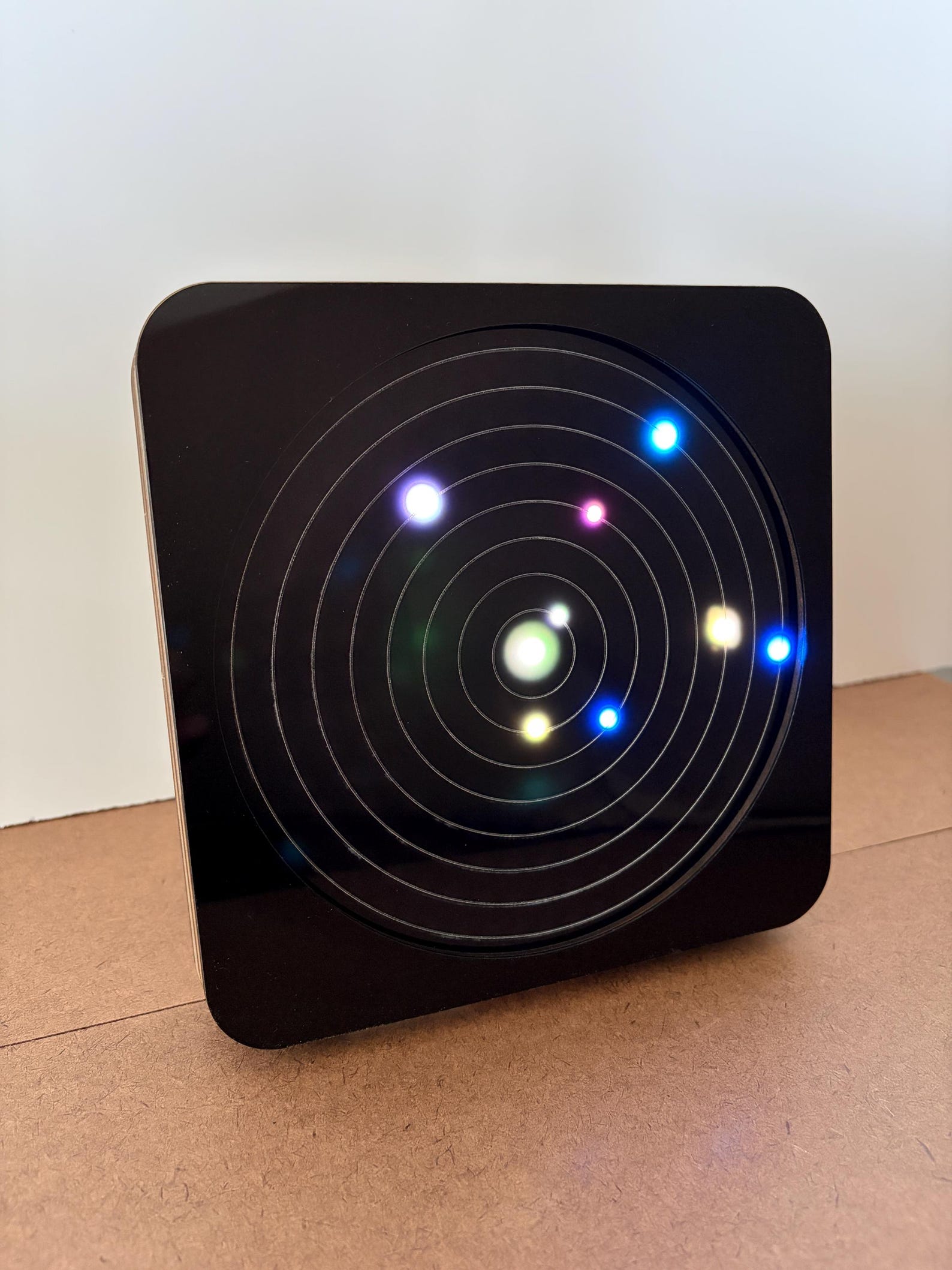 OrbiKron electronic orrery showing eight planets as colored points of light
