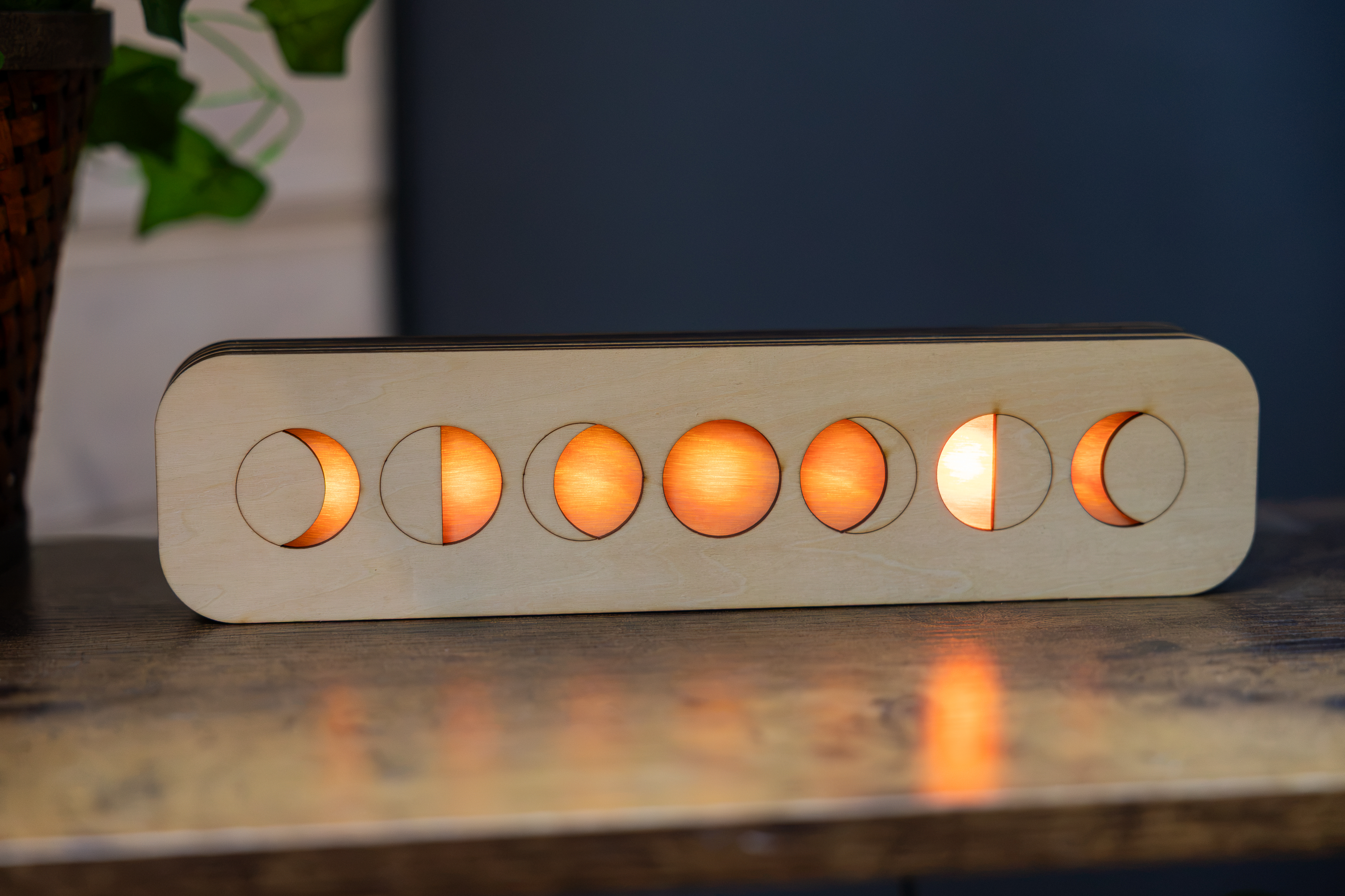 LunaKron 1 moon phase display glowing on a wooden tabletop
